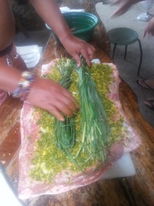 Rubbing the babi guling with spices.